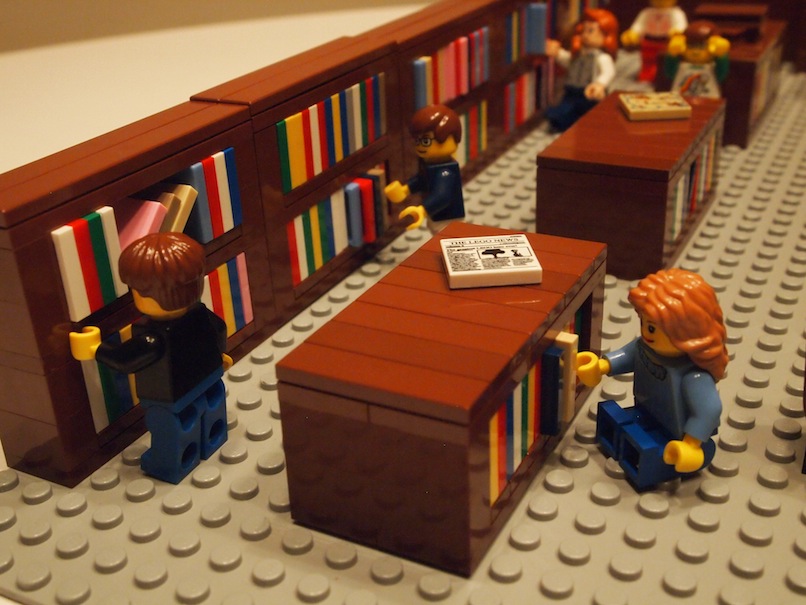 library patrons looking at bookshelves made from Lego pieces