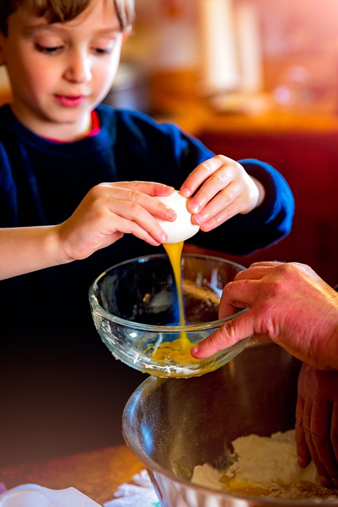child cracking egg into bowl