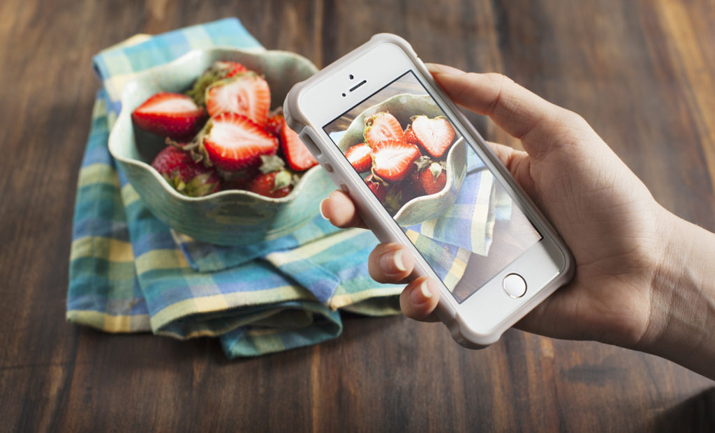 phone taking photo of strawberries