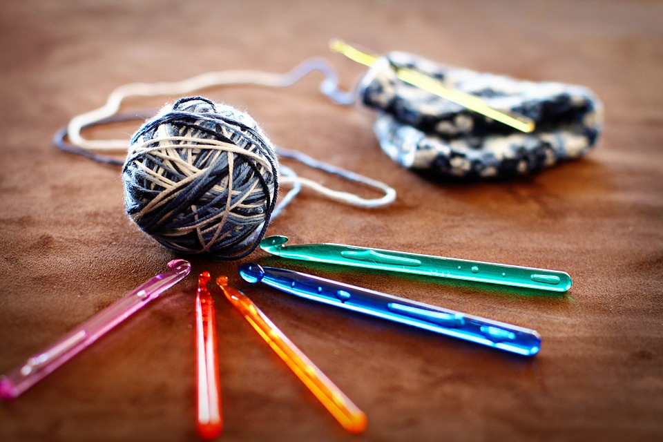 ball of yarn with colored crochet hooks