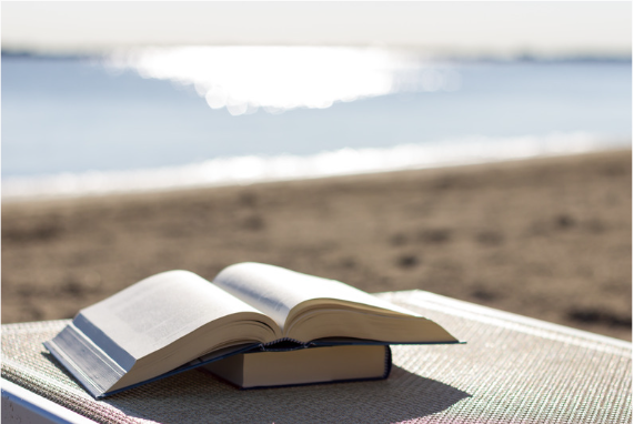 books on a blanket on the beach